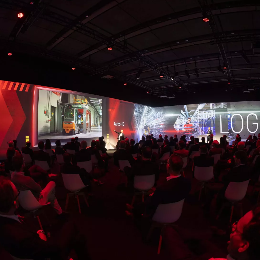 Porsche Consulting Global Operations Summit in Berlin People sitting in the immersive room with presentation