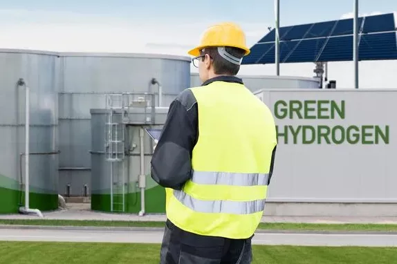Mann Steht vor Anlage mit grünem H2, Vorprodukt von eFuels