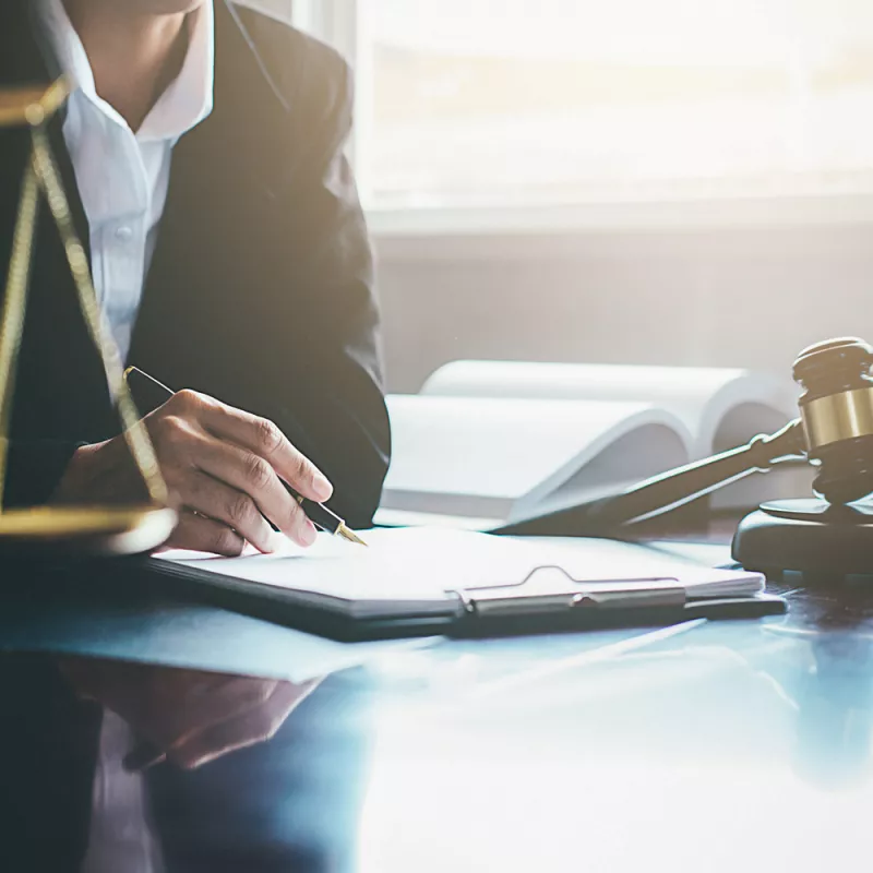 Close-up of a man writing something on a notepad