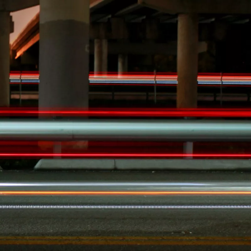 A man in a black jumper discusses with colleagues