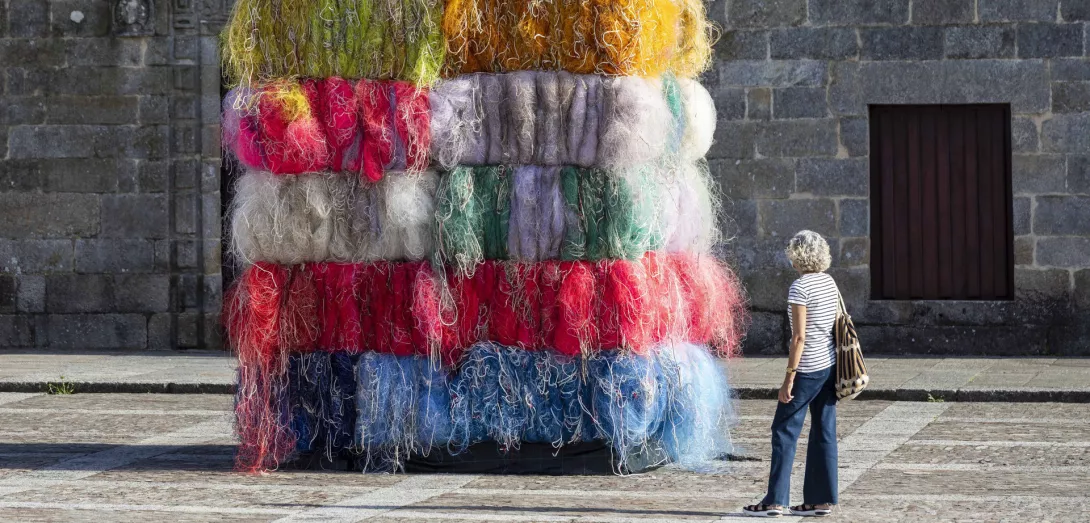Nachhaltigkeit stellt Gesellschaft und Wirtschaft vor große Herausforderungen. Wie schaffen wir eine lebenswerte Welt für Mensch und Natur? Der Künstler Manolo Paz regt mit bunten, zu Quadern aufgetürmten Fischernetzen zum Nachdenken an. Die Installation „Die Meere der Welt“ wurde im Sommer 2020 auf der Plaza de Fefiñáns im Ort Cambados an der Westküste Spaniens ausgestellt. CREDIT: Xurxo Lobato/Getty Images