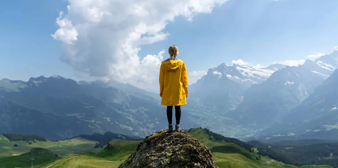 Woman standing on stone looking on mountains