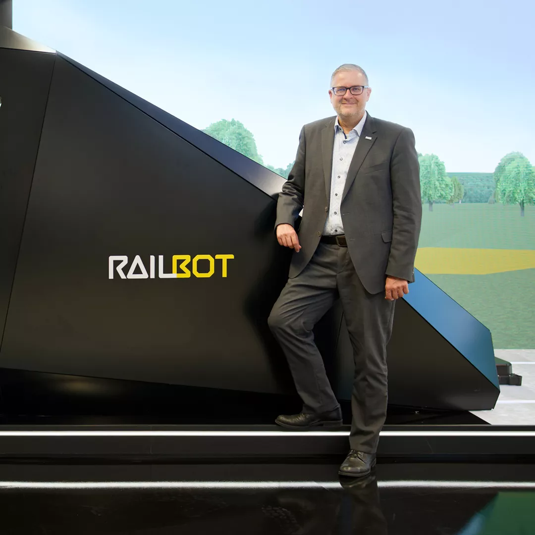 In front of the “Railbot” in the Hitachi Rail showroom in Ditzingen, near Stuttgart: In his role as Vice President Markets Germany & Global Account Manager Deutsche Bahn, Markus Fritz is driving forward the modernization of rail transport in Germany.