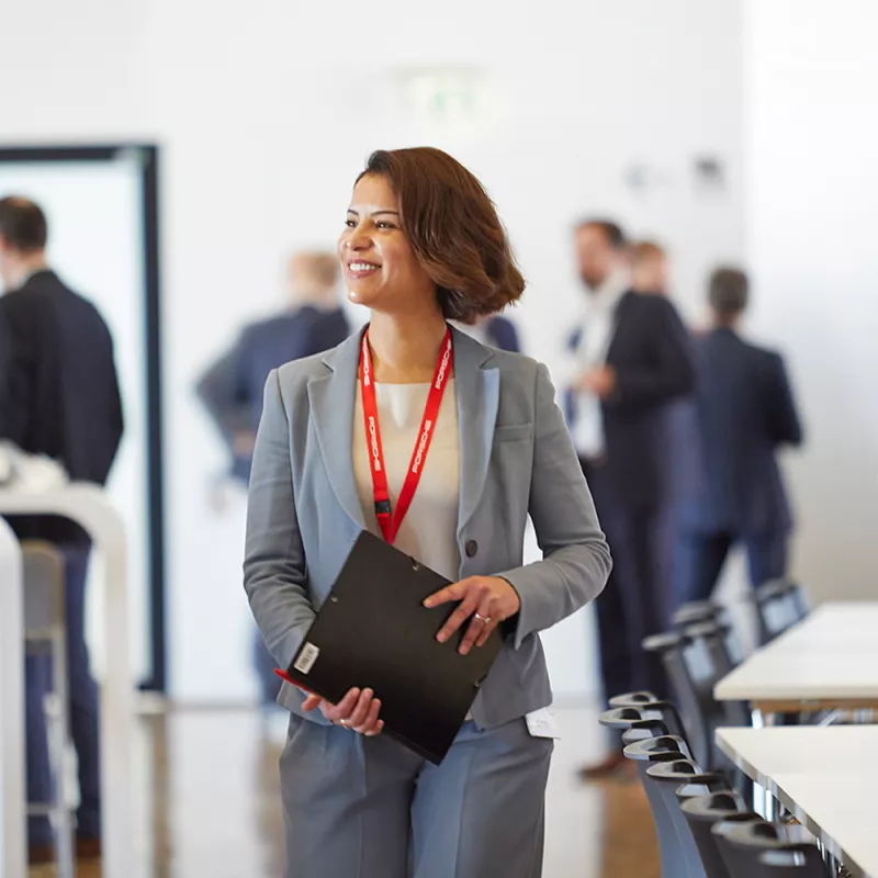 A young woman with a folder and a pen in a meeting room 