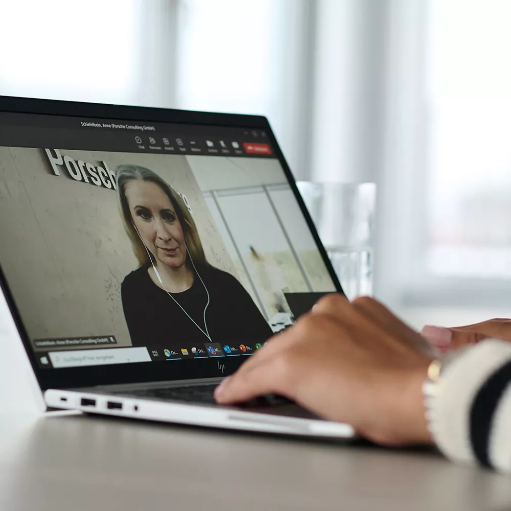Opened laptop with a female consultant in a zoom meeting on the screen