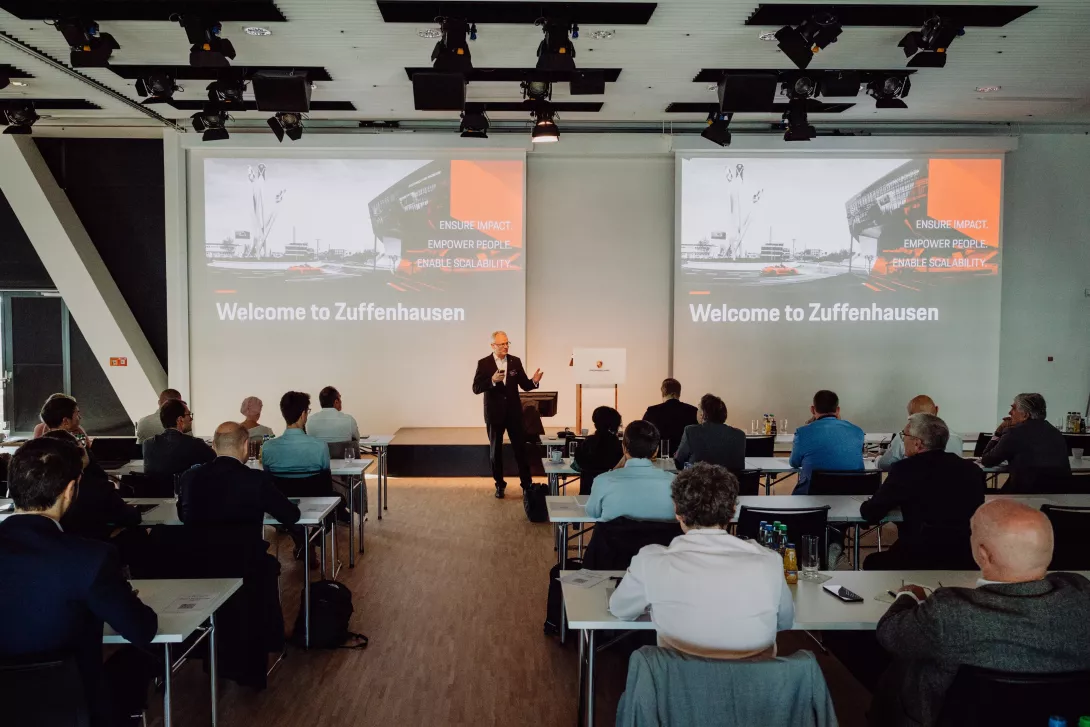 Speaker on stage welcoming the people to Zuffenhausen