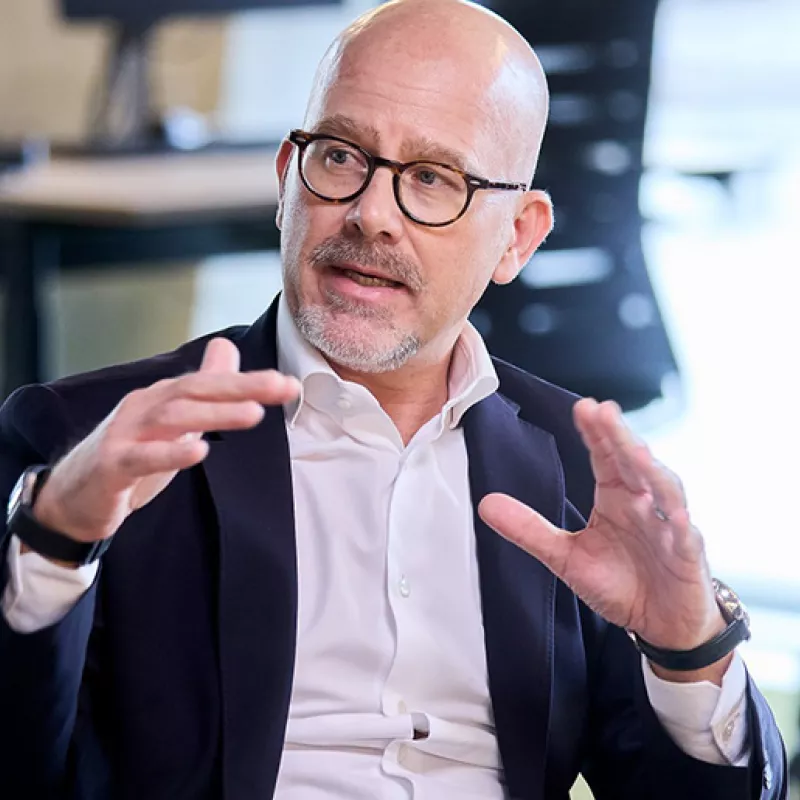 Sitting man in a suit discussing gesticulating 